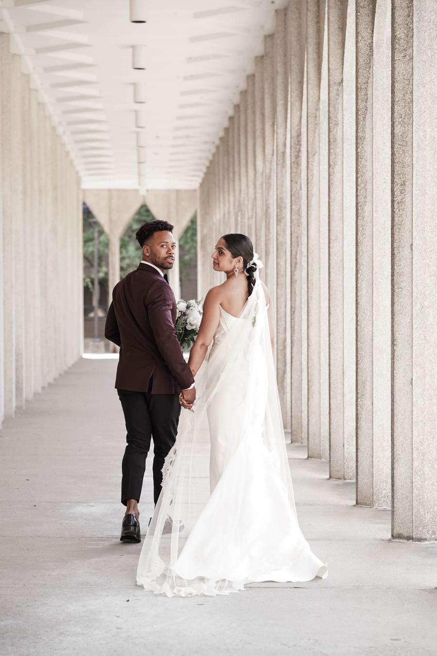 I and B walking hand in hand at their downtown Detroit wedding