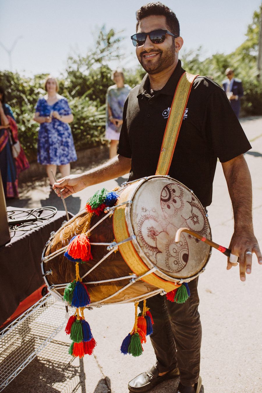 Dhol drummer leading the baraat procession at a Detroit fusion wedding